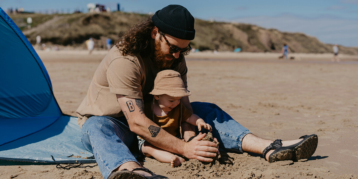 Movement Matters parent child playing with sand on beach